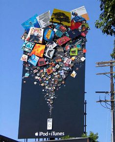 an advertisement for ipod and ituness on the side of a building in front of a blue sky