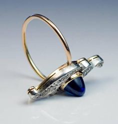 Made in Moscow between 1899 and 1908. An antique silver-topped 14K gold ring is centered with a high dome cabochon cut sapphire (6.7 x 5.7 x 6 mm, approximately 2.47 ct) set in a gold bezel. The sapphire is vertically flanked by two scrolls embellished with sparkling old mine cut diamonds. Estimated total diamond weight 0.80 ct. The ring is marked with 56 zolotnik Imperial gold standard, initials 'ИЛ' for Moscow assayer Ivan Lebedkin, and maker's initials 'BP'. Length 26 mm (1 in.) Ring size 8.5 Formal Domed Cabochon Sapphire Ring, Elegant Blue Cabochon Dome Ring, Vintage Oval Cabochon Sapphire Ring For Formal Occasions, Elegant Domed Gemstone Signet Ring, Classic Blue Domed Jewelry, Vintage Sapphire Oval Cabochon Ring Hallmarked, Vintage Oval Cabochon Sapphire Ring Hallmarked, Vintage Oval Cabochon Sapphire Ring, Vintage Oval Cabochon Sapphire Ring With Hallmark