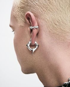 a man with piercings on his ears wearing a chain around his neck and earring