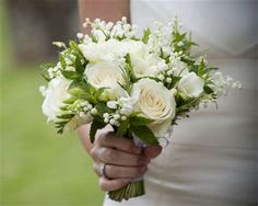 a bride holding a bouquet of white flowers