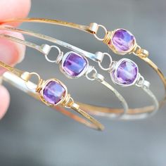 A simple, hammered 14K gold filled bangle features a gorgeous high quality Amethyst faceted cube secured with 14k gold filled wire in my original bezel wrapped style to create a beautiful bracelet that is eye catching alone or looks gorgeous stacked. This bangle has a hinge style clasp to make it easy to put on take off and fit better to your forearm / wrist. This would make a wonderful gift for a February birthday girl racelet - Choose your perfect fit. 7 - 7.5 inches in circumference is the mo Stackable Amethyst Gold Jewelry, Forearm Bones, Bezel Wire, Amethyst Bangle, Gold Arm Band, Bezel Bracelet, Bracelet Stacking, February Birthday, Gold Armband