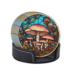 a glass plate sitting on top of a black leather belt with mushrooms painted on it