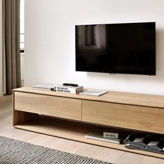 a flat screen tv mounted to the side of a wooden entertainment center in a living room