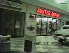 a white truck parked in front of a store next to a sign that reads mister move