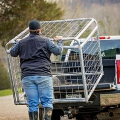 a man pushing a cage on the back of a truck