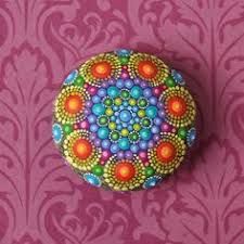 a colorful painted rock sitting on top of a pink wallpaper covered floor next to a purple background