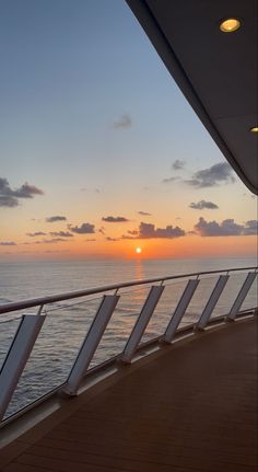 the sun is setting over the ocean as seen from a cruise ship's deck