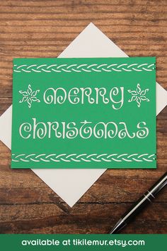 a green and white greeting card with the words merry christmas written in cursive font