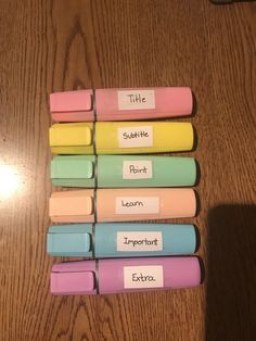 several different colored erasers sitting on top of a wooden table next to each other