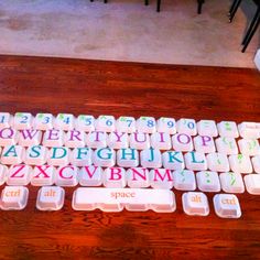 a keyboard with letters and numbers on it sitting on a wooden floor next to a chair