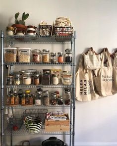 a metal shelf filled with lots of spices and other items next to a wall mounted bag