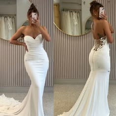 a woman taking a selfie in front of a mirror wearing a white wedding dress