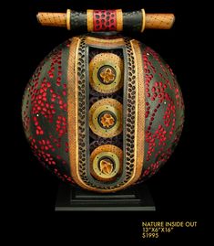 an ornate vase with decorative designs on the outside and inside is painted red, gold, and black