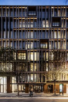 a large building with lots of windows on the front and side of it at night