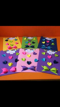 four different colored cards with hearts and bows on them, one is pink, the other is green