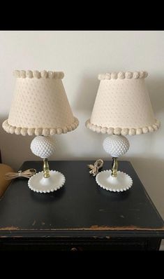 two lamps sitting on top of a black table