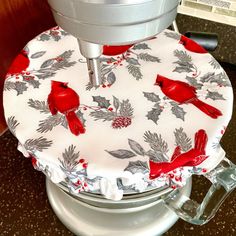 a red bird sitting on top of a white frosted cake pan covered in holly leaves