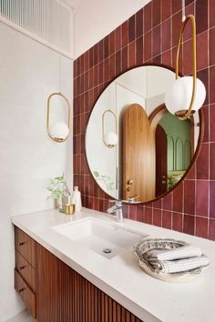 a bathroom with a sink, mirror and lights on the wall in front of it