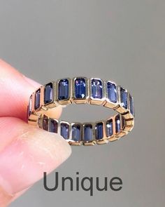 a gold ring with blue sapphires is shown in front of a gray background and the words unique written below it