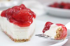 a piece of cheesecake with cherries on top is being held by a fork