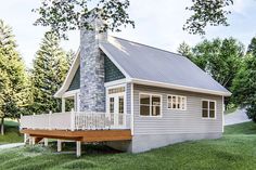 a small house with a porch on the grass