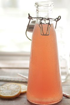 a glass bottle filled with liquid next to lemon slices