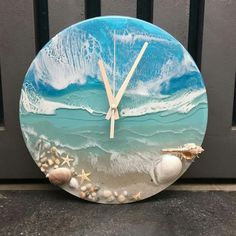 a clock that is on the side of a wall with seashells and starfish