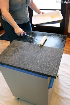 a woman is using a knife to cut something out of a box on top of a counter