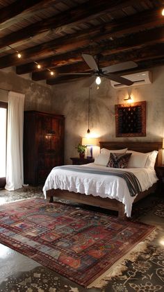 a bedroom with a bed, ceiling fan and rug on the floor in front of it