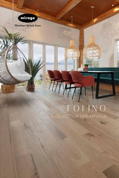 the interior of a house with wood flooring and white walls, red chairs and green table