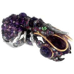 This envy inducing and thoroughly unique piece is an item that everyone will want to get their claws on. Skillfully crafted from a mix of superior and illustrious gems, you will find 56.69 carat Amethyst Quartz, 3.32 carat Blue Sapphire, 3.70 carat Pink Sapphire and a beautifully dark and foreboding 0.55 carat Tsavorite Garnet as a contrasting background. Speckled with stunning 1.71 carat White Diamonds and placed within a gold and palladium setting, this really is a maritime sight to behold. Ri Round Sapphire Ring, Jewelry Rings Unique, Rock Lobster, Amethyst And Citrine, Big Stone Ring, Blue Opal Ring, Vintage Cocktail Ring, Cocktail Jewelry, Tsavorite Garnet