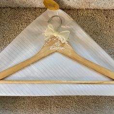 a pair of wooden clothes hangers sitting on top of a white cloth