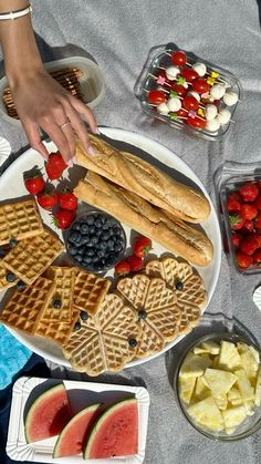 a plate with waffles, watermelon slices and strawberries on it