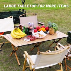 there is a table with fruit and drinks on it in the grass next to two chairs