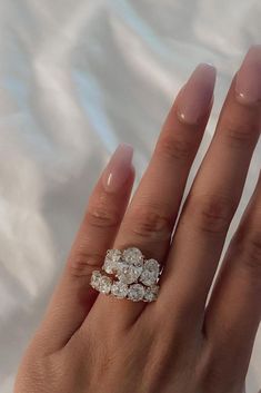 a woman's hand with three diamond rings on top of her ring and the middle finger