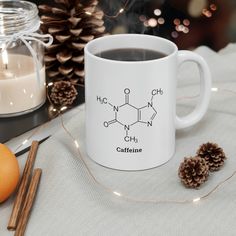 a coffee mug with caffeine written on it next to cinnamons and pine cones