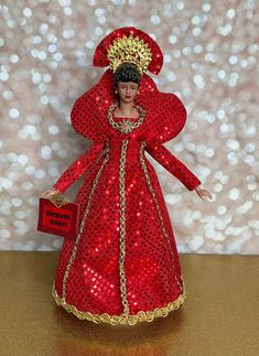 a red and gold figurine with a name tag in it's hand