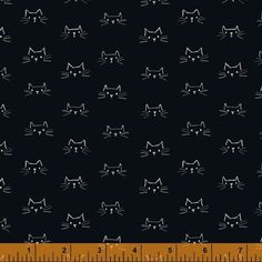 a ruler with cats on it next to a black background