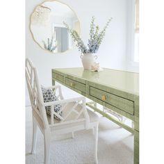 a white chair sitting next to a green dresser