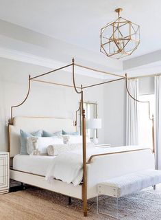 a bedroom with white furniture and a chandelier hanging from the ceiling above it