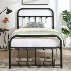 a black metal bed frame in a bedroom