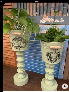 two green planters sitting on top of a wooden table