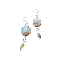 a pair of earrings with shells hanging from them