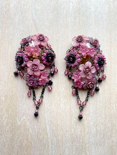 Spectacular Vintage Colleen Toland Fuchsia( bright and deep pink) and Black Beaded Floral Earrings.  These earrings are clip-on.  They are handbeaded with hand painted resin flowers and glass beads and metal roses.  There is a cluster of flowers that hug the ear complimented by a simple vee drop. The colors are striking and the style is elegant. These earrings were made in the early 2000s. The works shown in this shop are vintage Colleen Toland from past collections and they are the last of thes Pink Bohemian Chandelier Earrings For Party, Bohemian Pink Chandelier Earrings For Party, Handmade Pink Chandelier Earrings For Celebration, Elegant Pink Chandelier Earrings, Pink Dangle Chandelier Earrings, Pink Beaded Chandelier Earrings For Wedding, Handmade Pink Clip-on Earrings For Party, Handmade Pink Evening Earrings, Handmade Pink Earrings For Evening