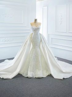 a wedding dress on display in a white room