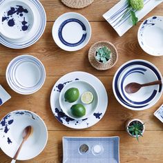 the table is set with plates, bowls and utensils in blue and white