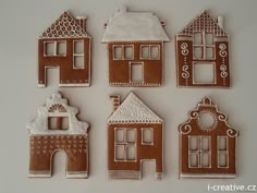 six gingerbread houses are arranged on a white surface