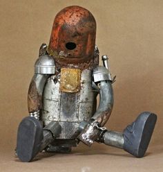 an old metal robot sitting on the ground