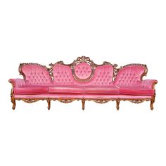 a pink couch sitting on top of a white floor next to a wooden frame with gold trim