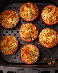 tomatoes stuffed with parmesan cheese and seasoning in an air fryer pan